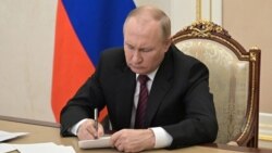 Vladimir Putin signs a document